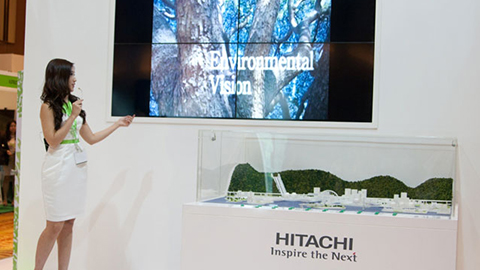 A Hitachi brand ambassador presenting a video on Hitachi's environmental vision and activities